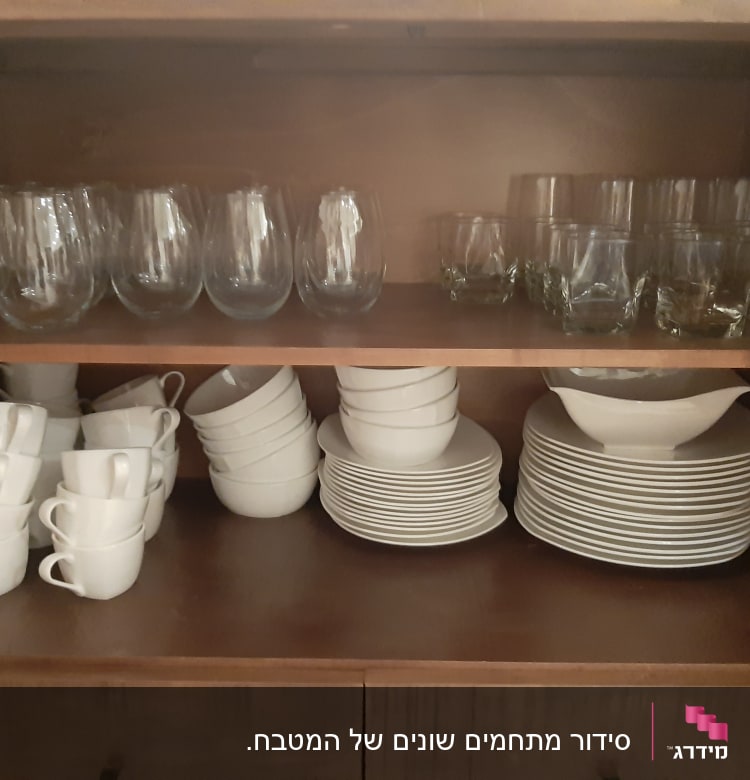 כוסות זכוכית, ספלים וצלחות מסודרים בארון מטבח